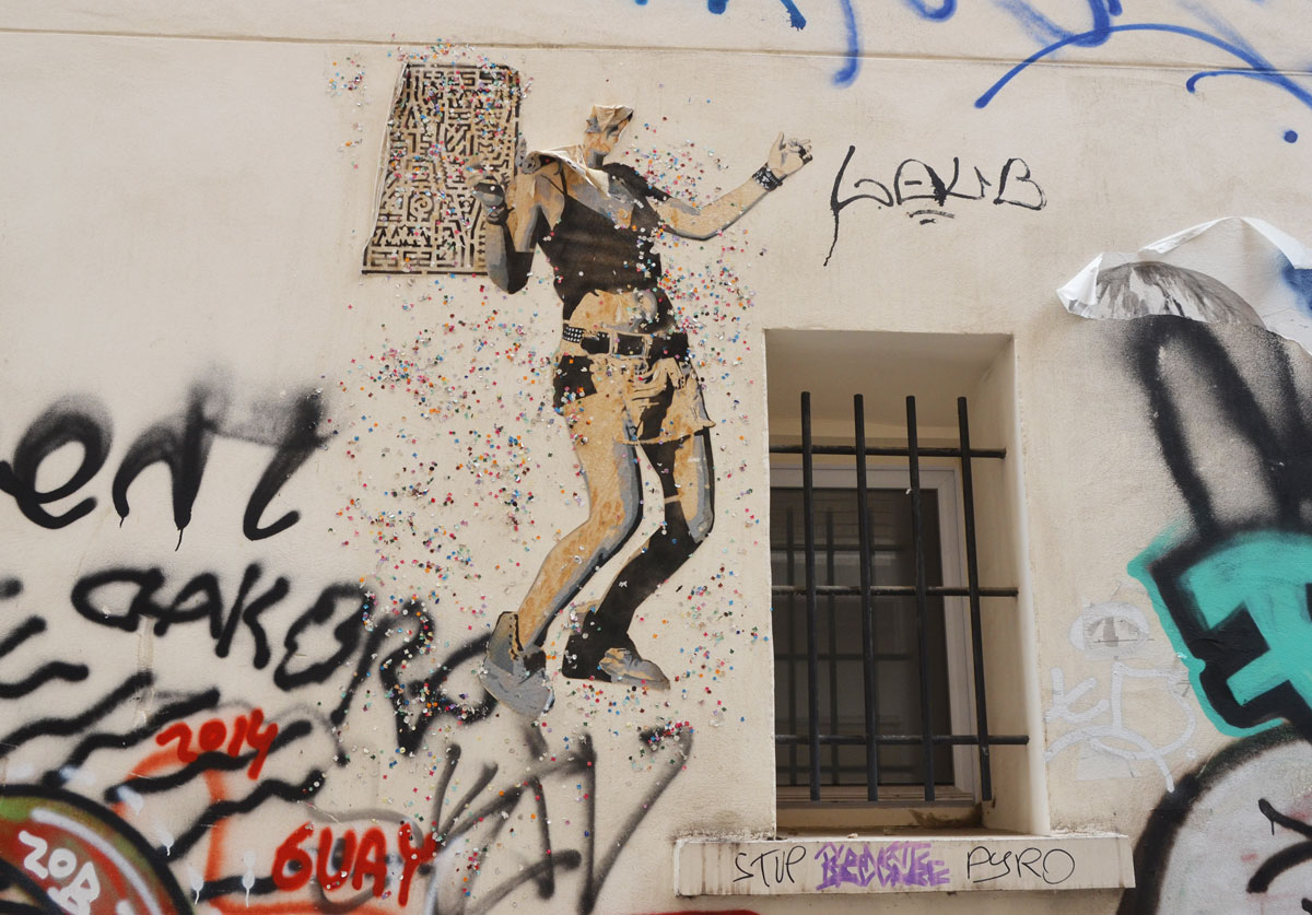 large size paper paste up of a young woman, standing, with a lot of small glittery pieces of paper scattered around her - wearing shorts with a belt, a wide bracelet. The top of her head has been ripped off. She seems to be dancing beside a window