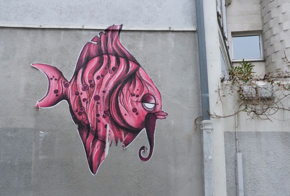big pink fish graffiti, with a half open eye and a moustache