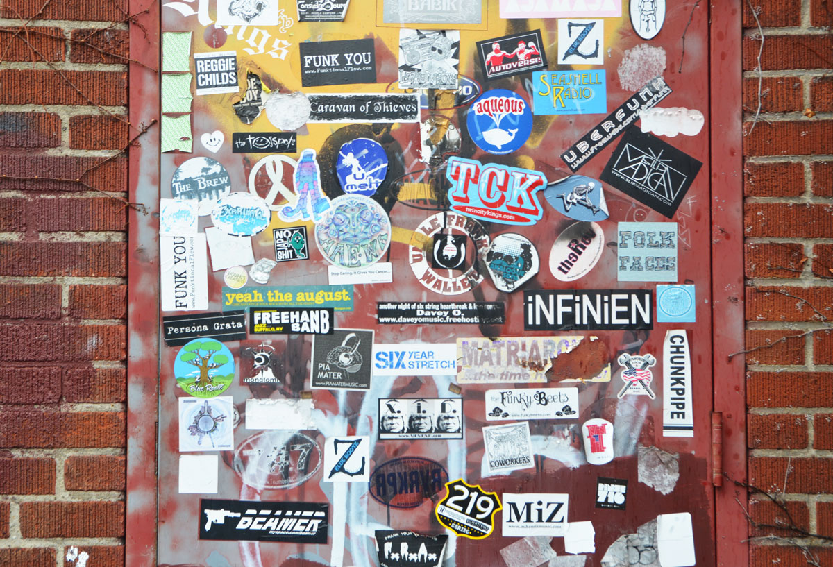 a door is covered with graffiti stickers. 