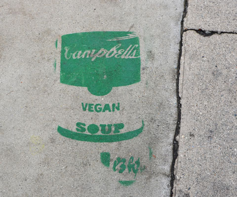 green stencil on grey concrete sidewalk, campbell soup can, vegan soup 