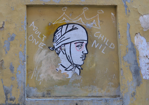 a paste up of a person's head wrapped in an old fashioned bandage that ties under the chin 
