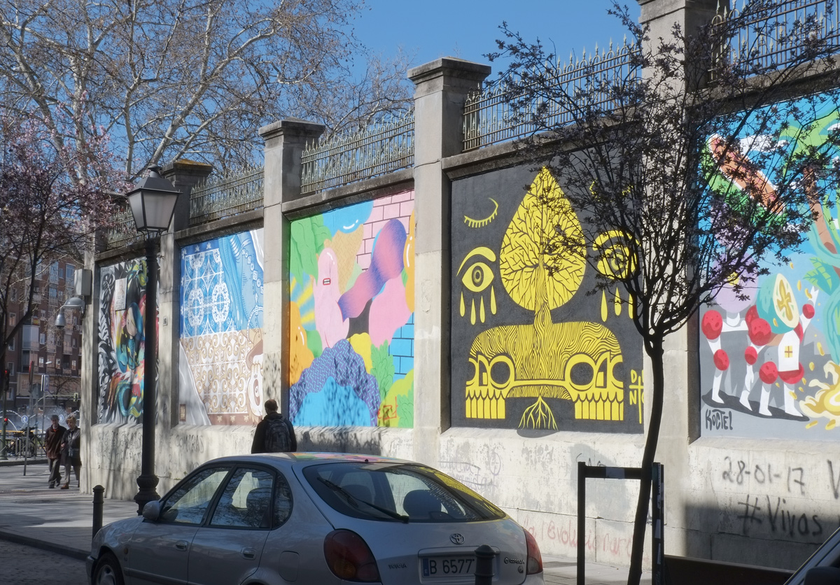 row of murals on a wall in Madrid