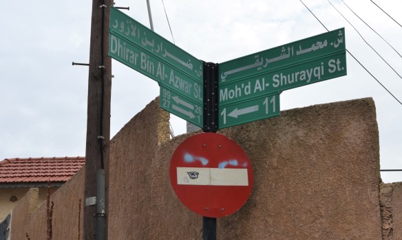 2 green street signs at an intersection in Amman Jordan along with a red and white do not enter sign 