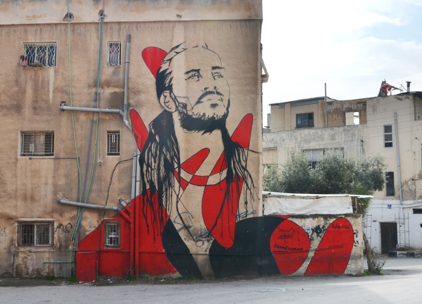 large mural in Al Hashmi Al Shamali in Amman of a man in black and red