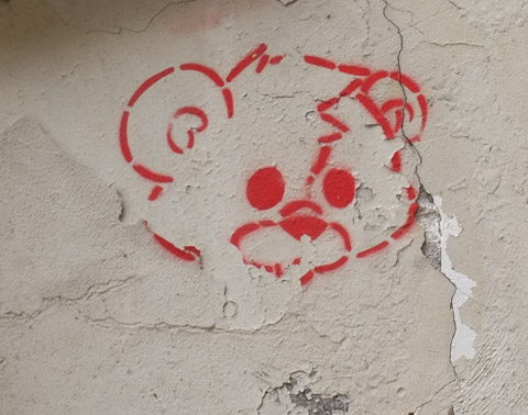 graffiti drawing in red, a teddy bear face