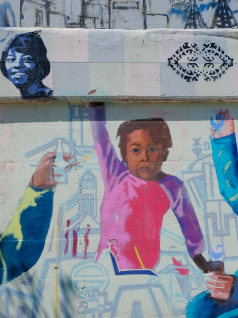 close up of part of mural, black girl wearing a pink and purple shirt 