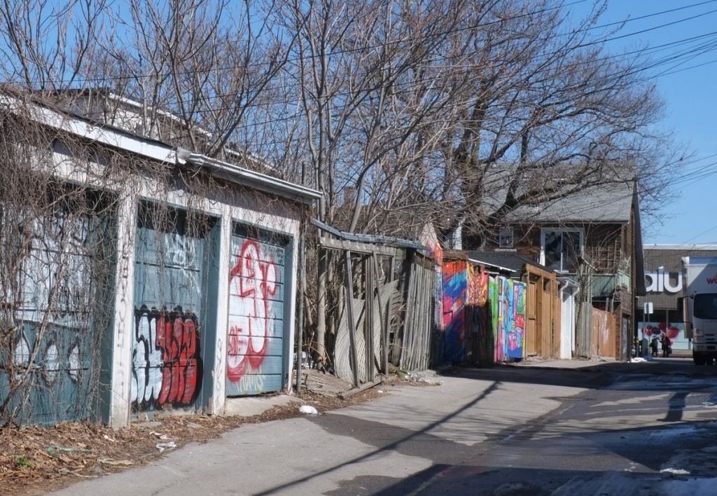 a line of garages with graffiti and street art, Paul Estrela Lane in Toronto 