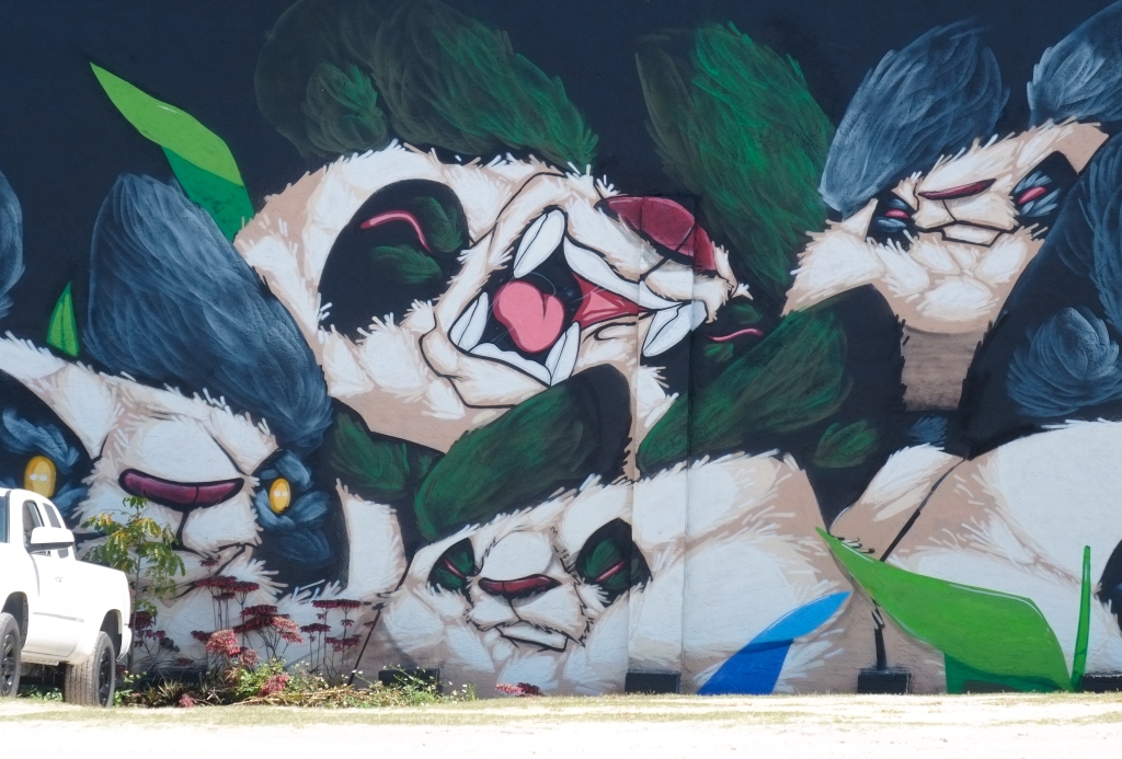 close up of pandas heads in mural with title laughing giants